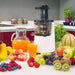 BioChef Atlas Slow Juicer in the kitchen sourounded by fruit and veg and juice that was made with it.