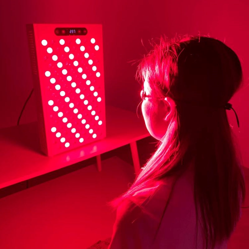 Woman using Innerlight Red Light Therapy Panel Mini