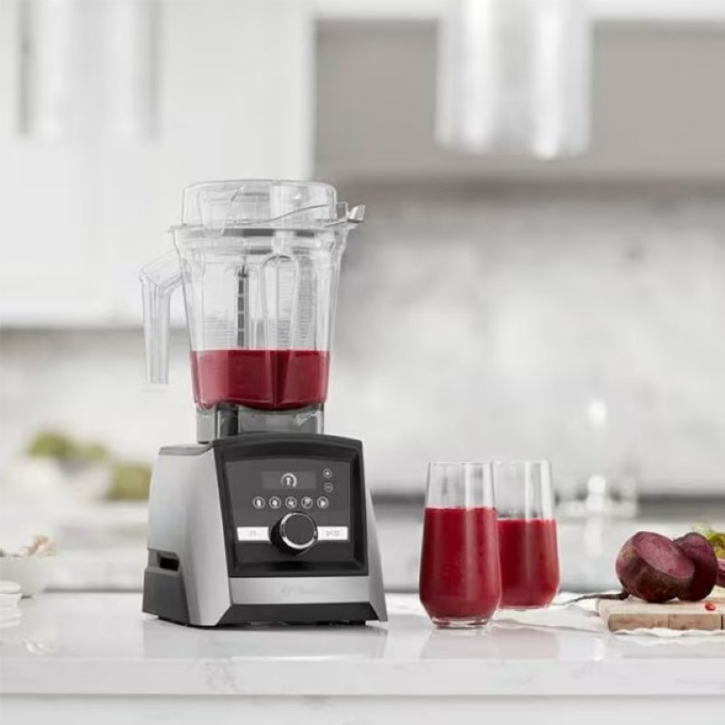 Vitamix Ascent Series A3500i in the kitchen with red smoothie inside and two glasses of smoothies on the side